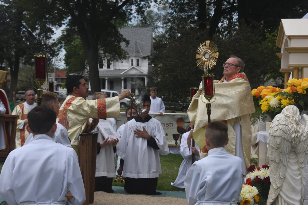 Deacon John Zak of St. Peter Parish in Omaha holds the Blessed Sacrament aloft during a Corpus Christi procession in 2021